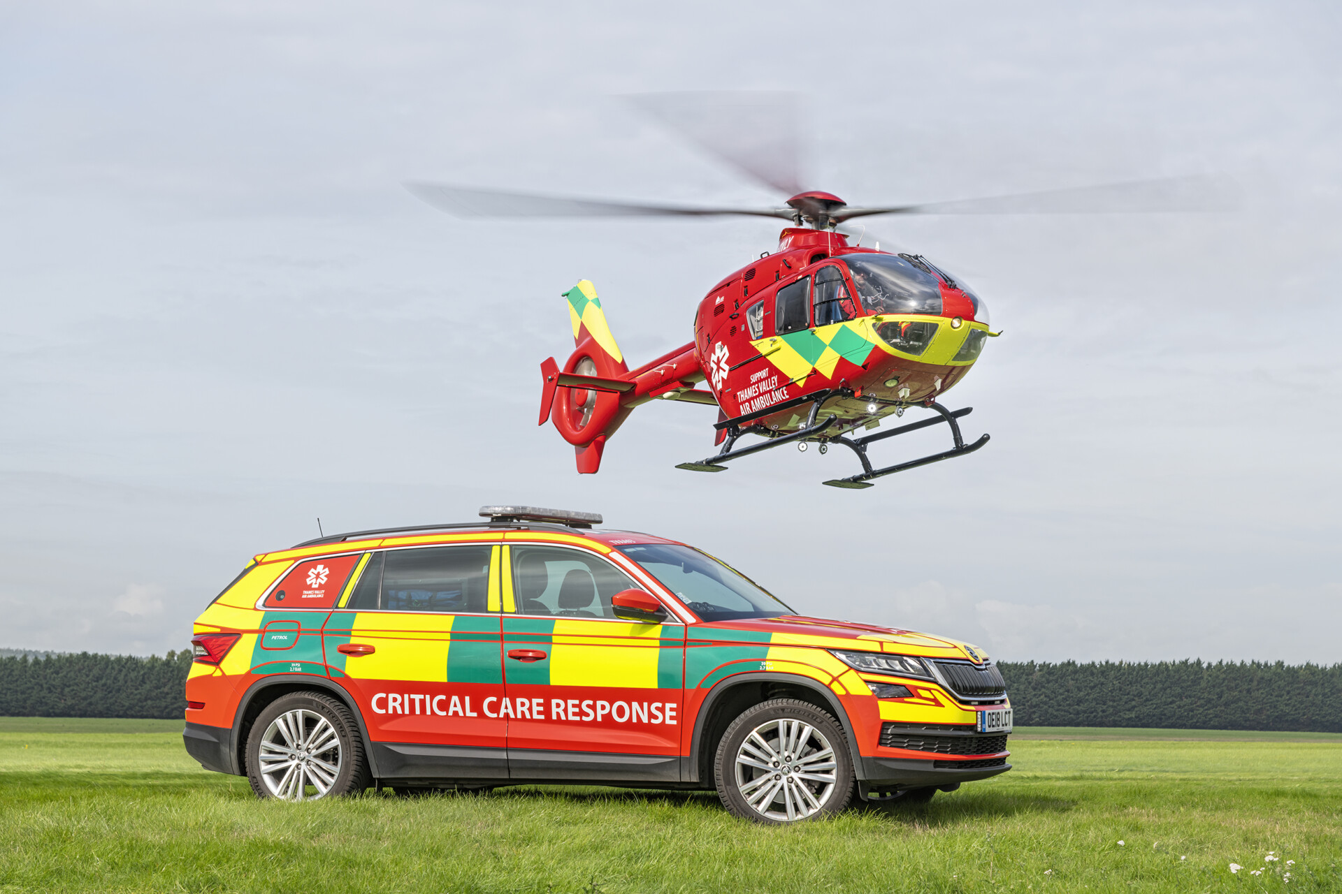 Thames Valley Air Ambulance helicopter in flight above a car