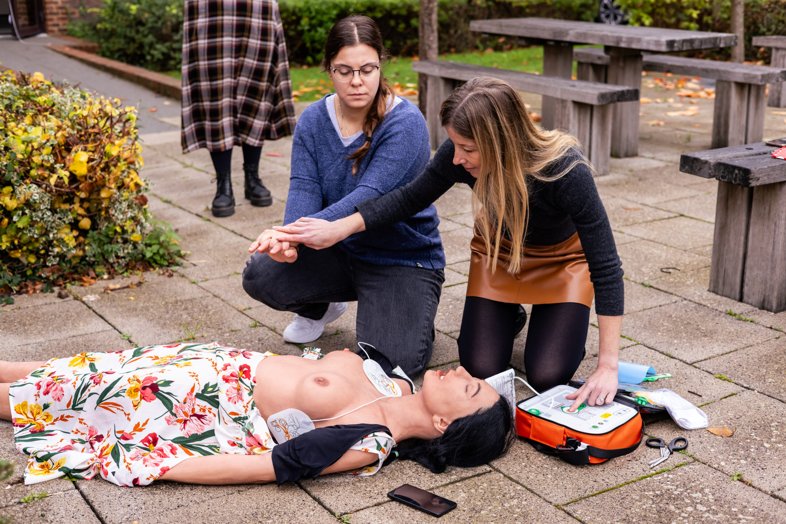 Bystander preventing anyone from touching the patient when AED shocks delivered during a cardiac arrest
